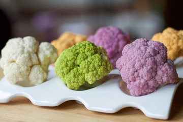 vaiety of cauliflowers  in different colors on a white plate