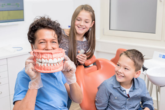 Lachende Kinder mit Zahnärztin haben Spaß