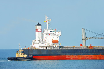 Tugboat assisting bulk cargo ship