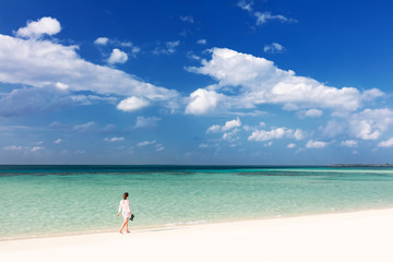 Fototapeta na wymiar Woman walking on tropical beach in Maldives