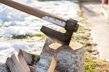 Axe stabbed in the firewood in the yard
