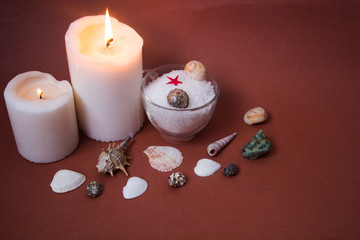 Spa concept. Seashells , candles and  sea salt  on brown background