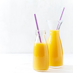 Mango and apple smoothie in glass bottles

