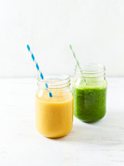 Banana-orange and banana-kale smoothie in glasses

