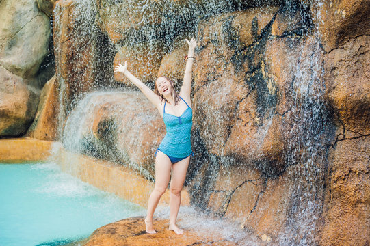 Young Woman Relaxing Under A Waterfall In Aquapark