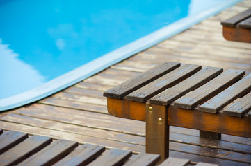 dark deck board and deck chairs by the outdoor pool