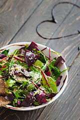Fresh organic green quinoa salad bowl on dark wooden background