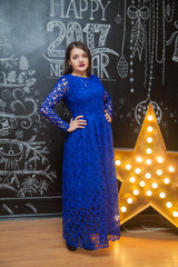cute brown-haired woman in a blue evening dress lace