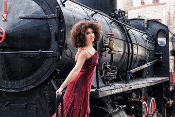 ragazza in abito da sera su un'antica locomotiva