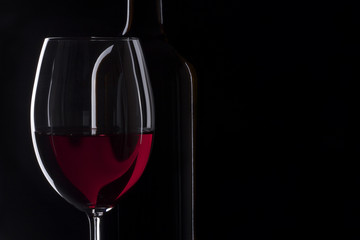 Wine glass and bottle with black background