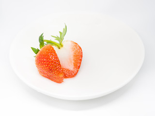Closeup of fresh strawberry on white plate isolated on gray background