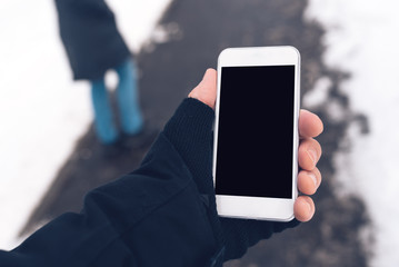 Mobile phone and male hands with winter gloves