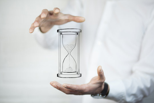 Man's hand holding hourglass sand