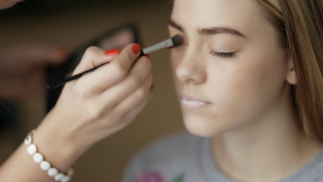 Master doing makeup for model