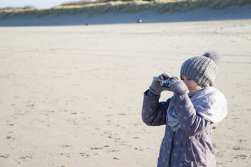 Mädchen fotografiert das Meer vom Strand aus