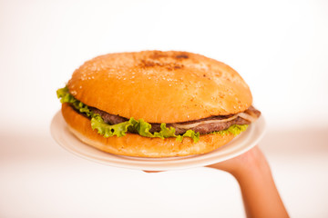 Woman eats hamburger isolated over white background