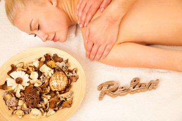 Beautiful blonde woman enyoing massage treatment in sap salon