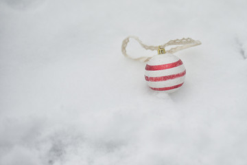 Obraz na płótnie Canvas Striped Christmas balls on the Christmas tree and the snow