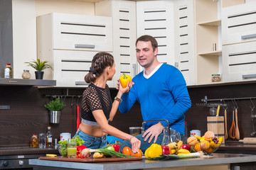 Young couple having fun in the kitchen preparing dinner