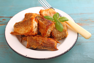 fried hake fish in a white plate