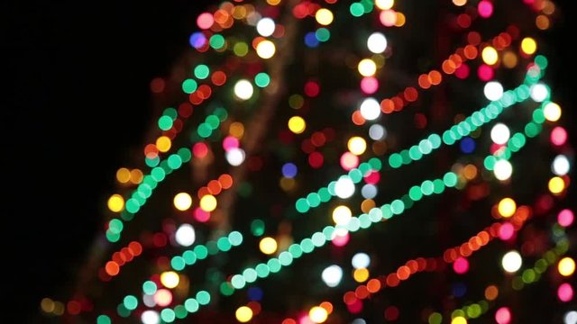 Christmas tree with colorful bokeh and christmas lights..Christmas and new year decoration. Abstract bokeh holiday background. Blinking garland. Christmas lights twinkling.
