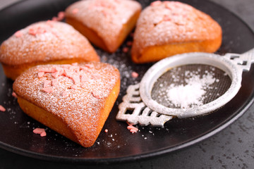 Fore cupcakes in heart with powdered sugar on a black plate. Valentines day.
