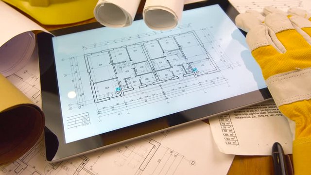 blueprints, tablet and other stuff on table