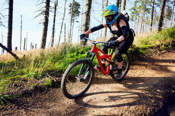 Fototapeta na wymiar Woman riding mountain bike MTB downhill in woods