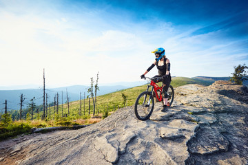 Fototapeta na wymiar Female MTB mountain biker enjoys the view during sunny day in Mountains