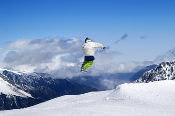 Naklejka na ściany i meble Snowboarder jumping in terrain park at ski resort on sun winter