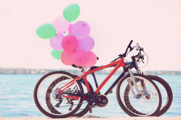 Fototapeta na wymiar Colorful balloons and bicycles on river shore