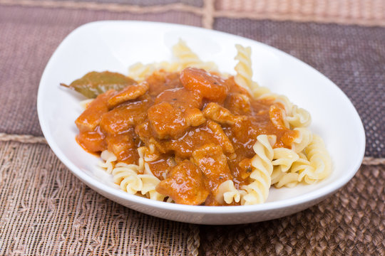 Pork goulash served on the plate with pasta