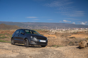 the car in the desert in the background of mountains with windmills. Transportation on Tenerife island. Canary islands