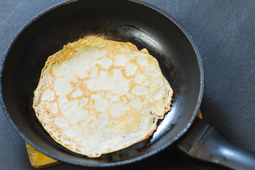 Stack of pancakes on frying pan.