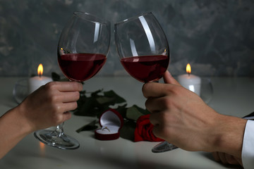 Man and woman hands holding red wine glasses in restaurant