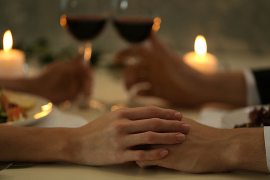 Couple holding their hands in restaurant