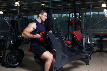 Obraz na płótnie Canvas Young handsome man training in gym