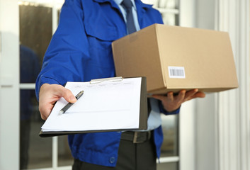 Courier with parcel and clipboard on doorstep, closeup