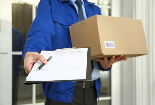 Courier With Parcel And Clipboard On Doorstep, Closeup