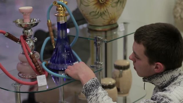 Young person chooses a hookah in the shop
