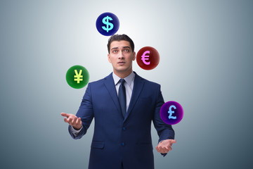 Businessman juggling between various currencies