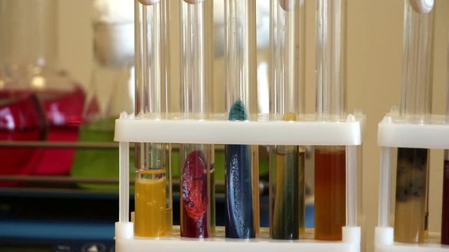 Colorful agar tubes with living bacteria on the blurred laboratory shaker moving background.  Lockdown. 