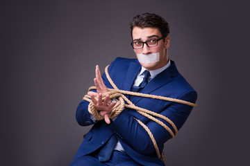 Businessman taken hostage and tied up with rope