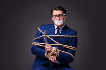 Businessman taken hostage and tied up with rope