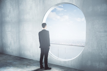 Thoughtful businessman in concrete interior side