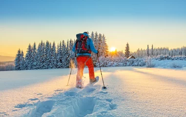 Fotobehang Wintersport Sneeuwschoenwandelaar die in poedersneeuw loopt