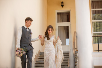 Fototapeta premium Wedding couple, beautiful bride and elegant groom going from home to place of wedding ceremony