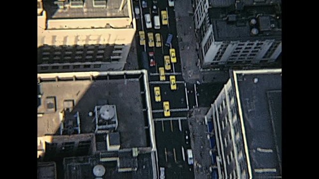 vintage panorama on seventy from Empire State Building top, aerial view of typical yellow taxis in the Manhattan traffic. New York, United States of America - circa 1970.