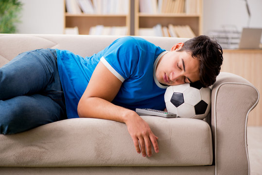 Man watching football at home sitting in couch