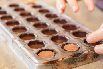 Filling out candy mold form with the chocolate
